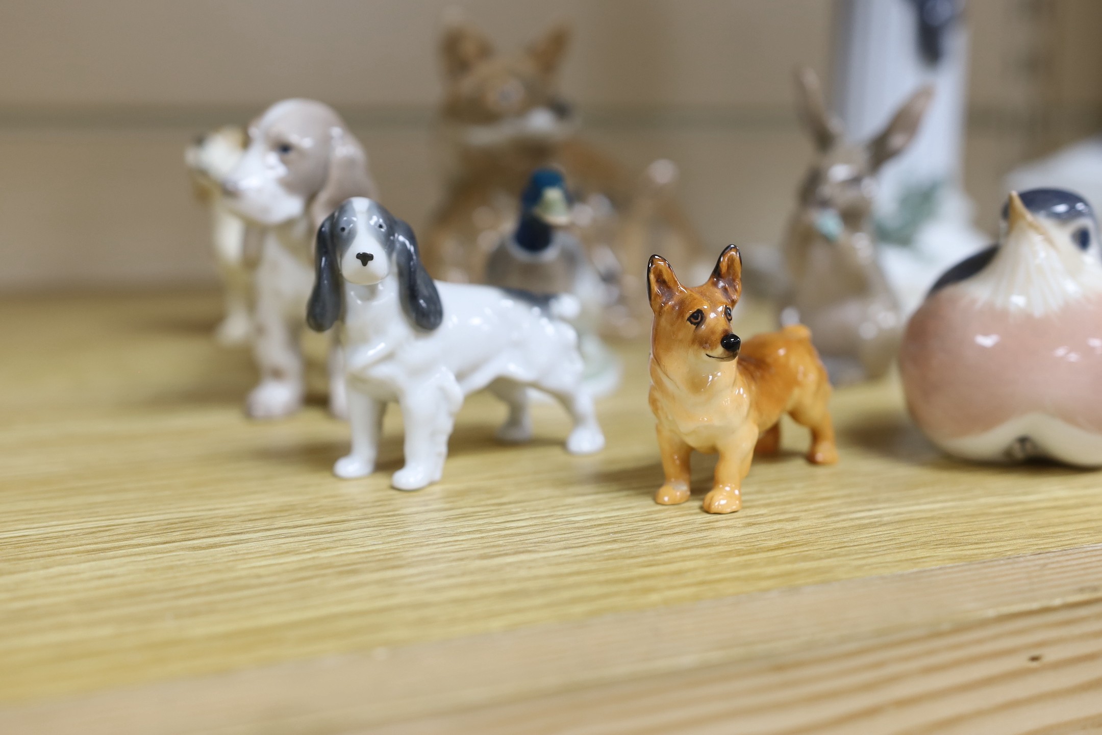 Sixteen various Royal Copenhagen porcelain birds and animals, including a faun playing pipes, a fox group and a metal foxhound, faun 21 cms high